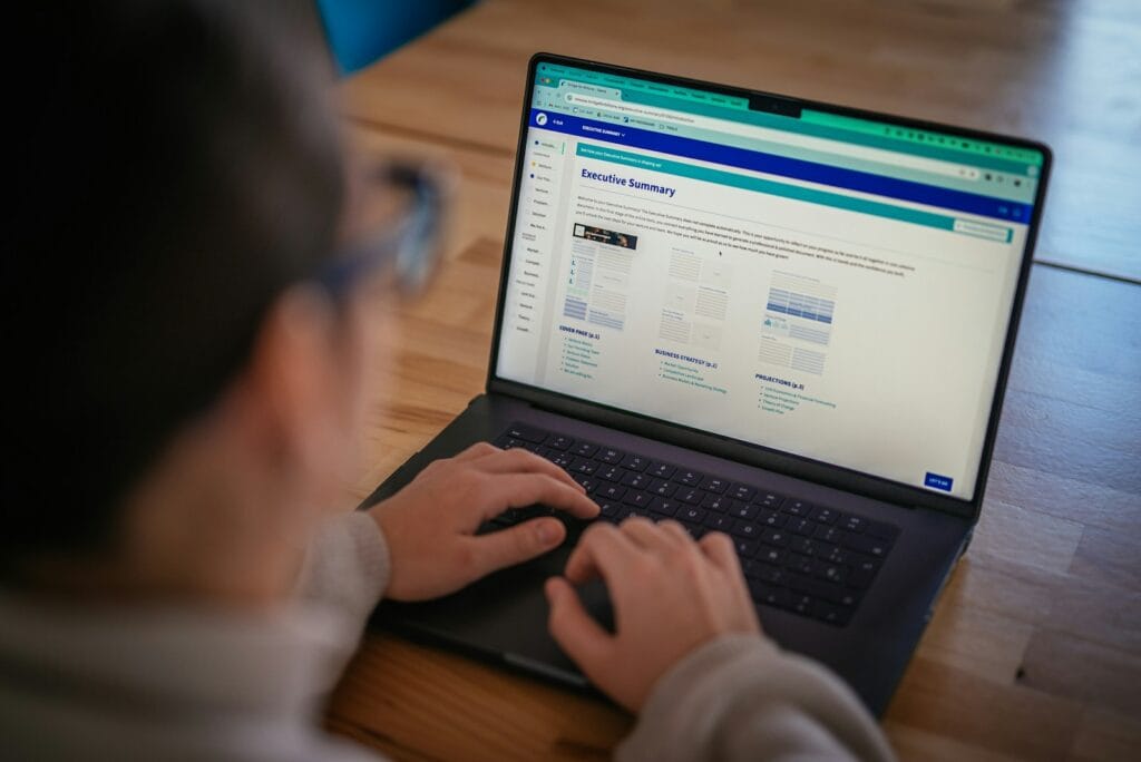 Assistente de Atendimento e Analista Administrativo Remotos Someone is using a laptop, viewing a webpage.