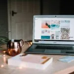 Vagas Remotas na Knewin turned on Acer laptop on table near cup