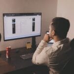 Vagas de Emprego na Agile a man sitting at a desk looking at a computer screen