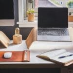 Vagas Remotas na Editora Dialética A stylish and contemporary home office setup with laptop and desk accessories.