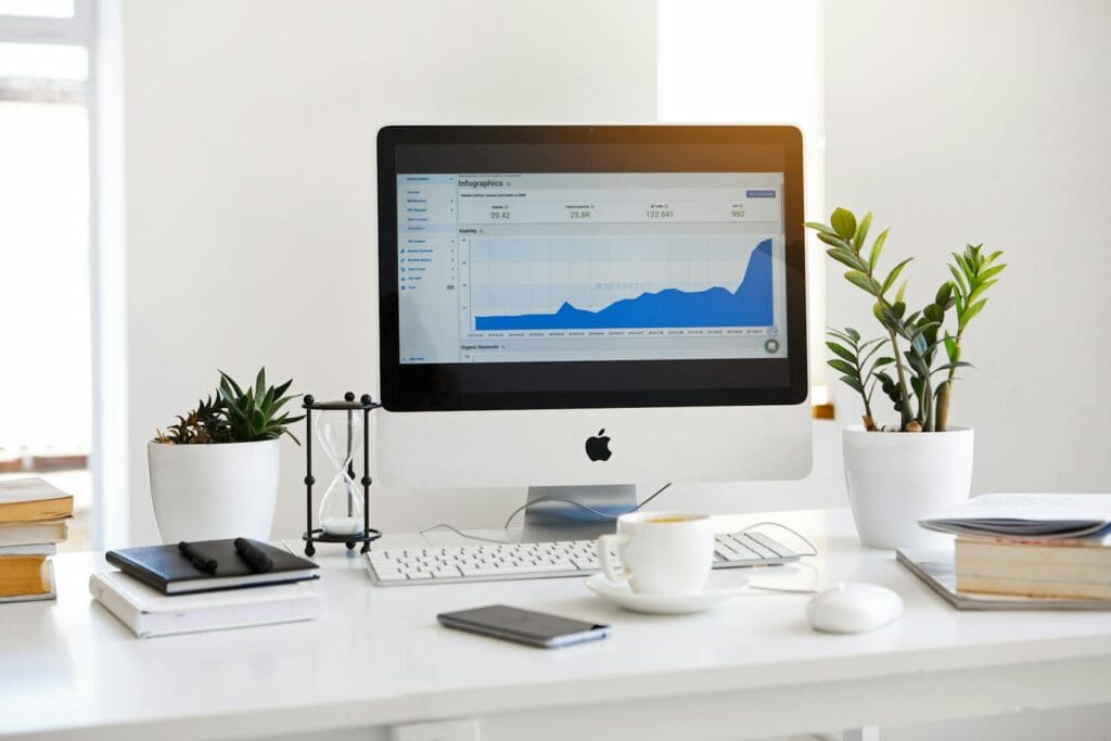 Vagas Remotas na Telemont, incluindo para Ensino Médio A clean, contemporary workspace featuring a desktop with analytics on the screen and plants for a fresh look.