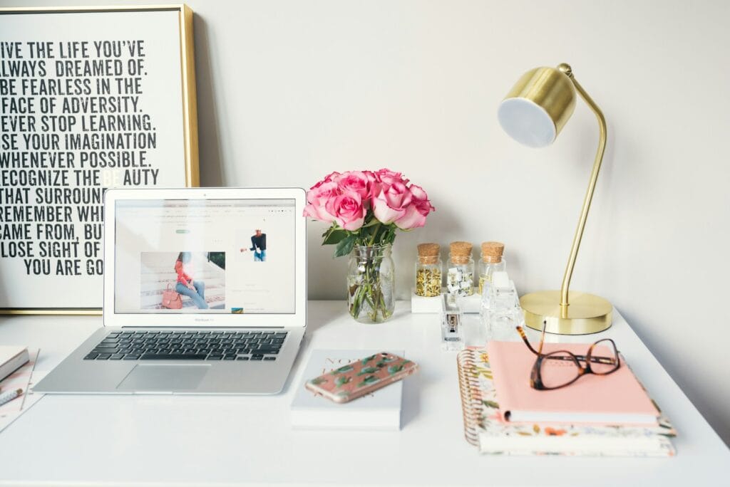 Auxiliar de Atendimento e mais Vagas Home Office MacBook Air beside gold-colored study lamp and spiral books