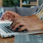 Vagas de Emprego Remoto na Nibo (CLT) Person typing on a laptop computer at a desk