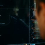 Desenvolvedores X Agentes de Automação: qual será o futuro do trabalho no setor de tecnologia? person facing computer desktop