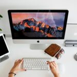 Home Office na Effecti person using silver imac and apple magic keyboard