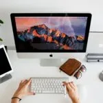 Vagas Remotas na Certsys person using silver imac and apple magic keyboard