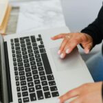 Vagas remotas na SuperFrete Close-up of hands typing on a laptop, ideal for tech and lifestyle themes.