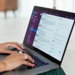 Vagas Remotas Abertas na Unifique Woman typing on a laptop using a messaging app in a home setting, close-up of hands.