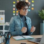 Vagas Remotas para Atendimento Woman gesturing while on a video call at desk.