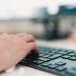 Smart NX contrata para 100% Remoto person using black computer keyboard