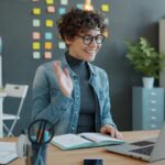 Sucesso do Cliente Home Office com VR de R$ 900,00 Woman waving hello during a video call at desk