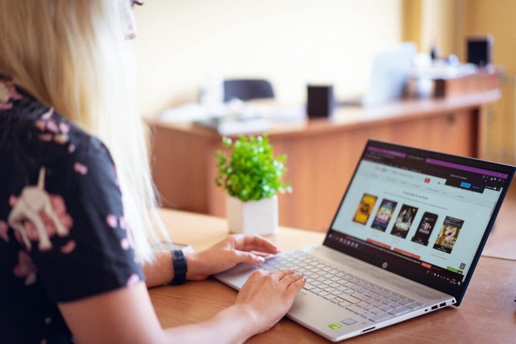 Vagas de Emprego na BeFly A woman browsing an online store on a laptop in a modern home office setting.