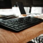 Oportunidades de emprego CLT Home Office black computer keyboard on brown wooden desk