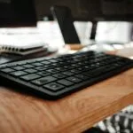 Oportunidades de emprego CLT Home Office black computer keyboard on brown wooden desk