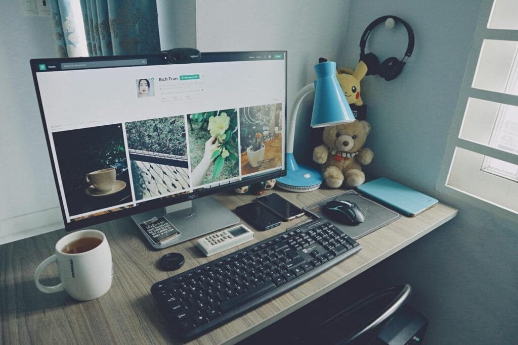 Teletrabalho com VR/VA até R$ 1.500! A tidy home office desk setup with a computer, keyboard, and personal items, creating a cozy work atmosphere.