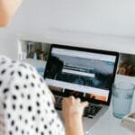Vagas remotas para Auxiliar Administrativo e + A woman working from home on a laptop, illustrating a freelance lifestyle.