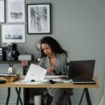 4 Vagas Remotas em Diferentes Empresasrofessional woman working at a desk in a stylish home office setting with decor and gadgets.