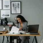 4 Vagas Remotas em Diferentes Empresasrofessional woman working at a desk in a stylish home office setting with decor and gadgets.