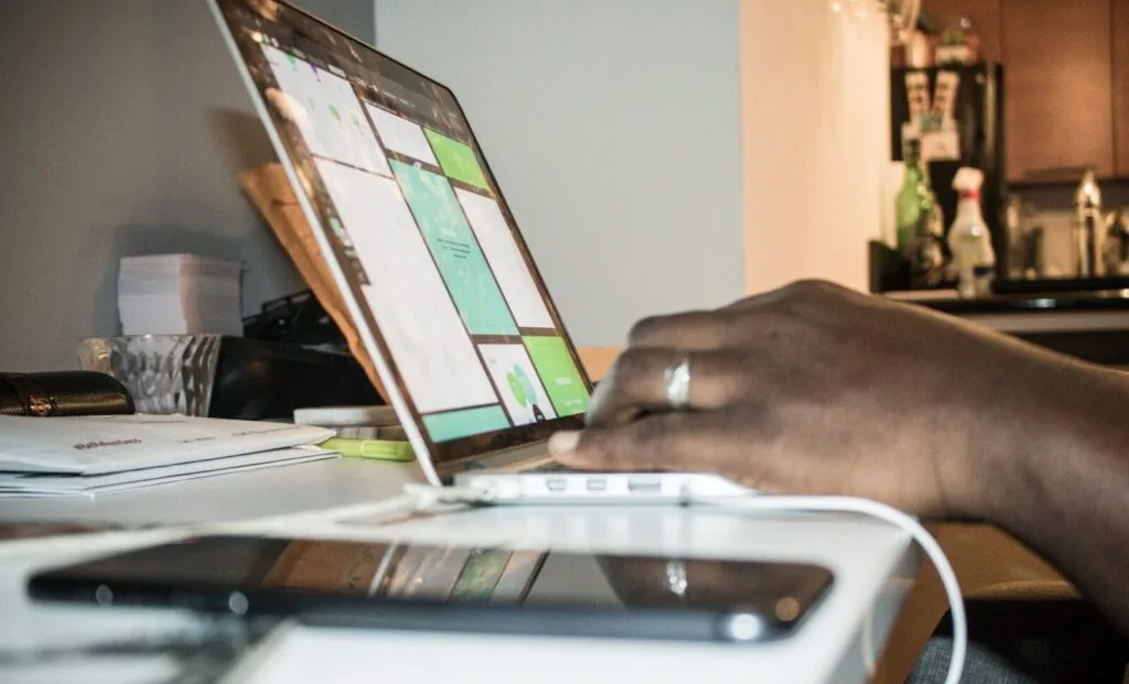 Ativa GR contratando para Home Office Focused setup of person working on a laptop in a home office environment with technology and documents.