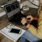 Vagas Remotas Abertas! person in blue denim jeans using macbook pro