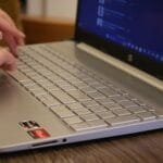 CLT Remoto com salário até R$ 12.000 Hands typing on a silver laptop keyboard, showcasing productivity and technology.