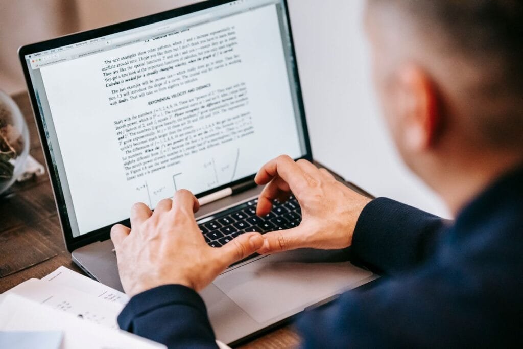 Suporte Técnico e +vagas com R$ 1.012,50 de VA/VR Man typing on laptop at home office, focused on work, illustrating remote work lifestyle.