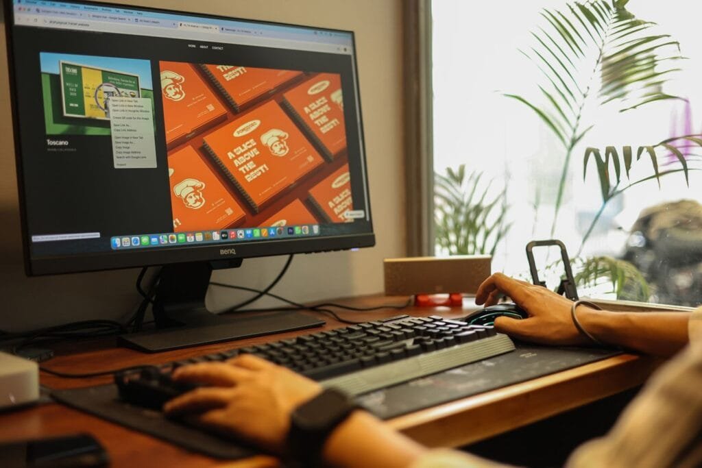 Analista de Growth e +Vagas Remotas com R$ 1.700 de VR/VA Hands working on a computer in a modern office setting, showcasing a focused and productive environment.