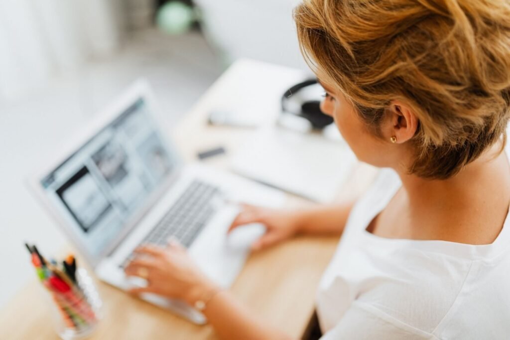 Vox Tecnologia: Remotas com VA/VR de R$ 800,00 A woman focused on her laptop in a modern home office setting, showcasing productivity.