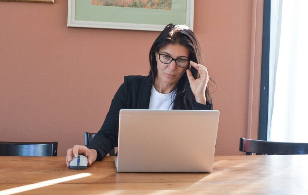 Professores: vagas 100% remotas abertas! Woman in glasses working on laptop at desk
