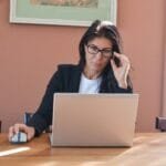 Professores: vagas 100% remotas abertas! Woman in glasses working on laptop at desk