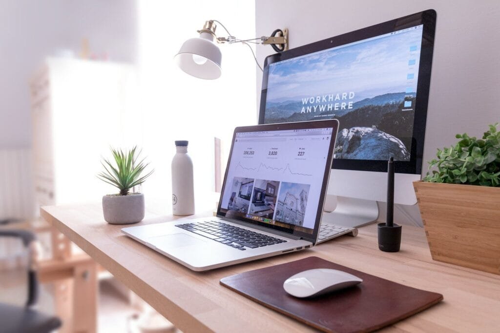 Vagas 100% remotas na Techne MacBook Pro on table beside white iMac and Magic Mouse
