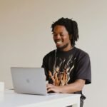 man in black crew neck t-shirt using macbook