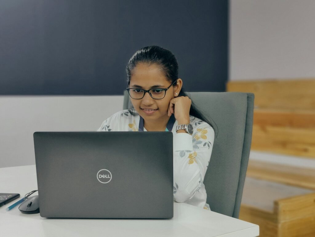 Analista Administrativo e +Remotas com VA/VR de R$ 700,00 a woman sitting in front of a laptop computer